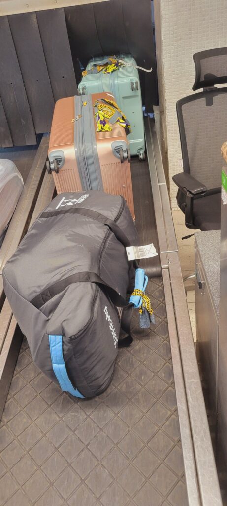 Our car seat in its travel bag on the check-in belt at the airport in Abidjan, Ivory Coast (Côte d'Ivoire)