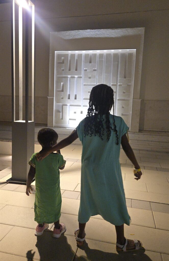 The kids walking together, seen from behind, on a warm evening in Dubai, United Arab Emirates
