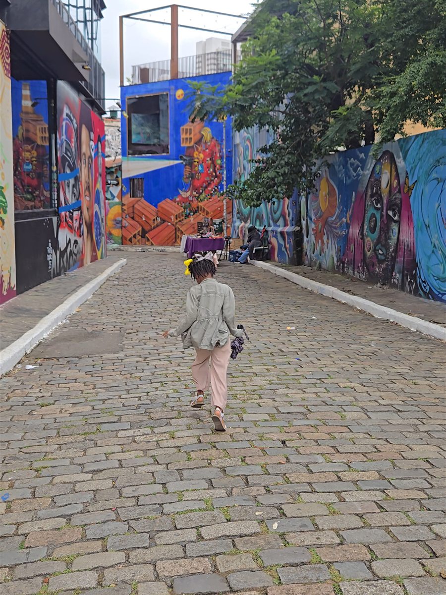 A child walking down a street art alley in Vila Madalena, Sao Paulo