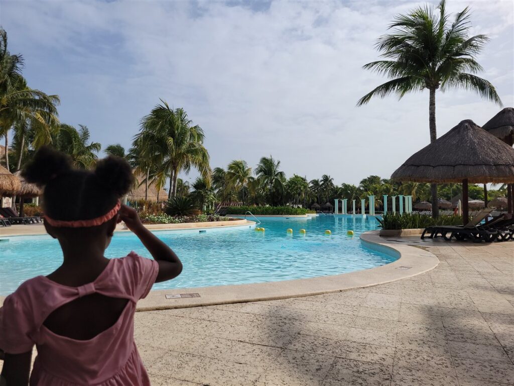 Our daughter, seen from behind, looking at the family pool at the Grand Palladium in the Riviera Maya, Mexico
