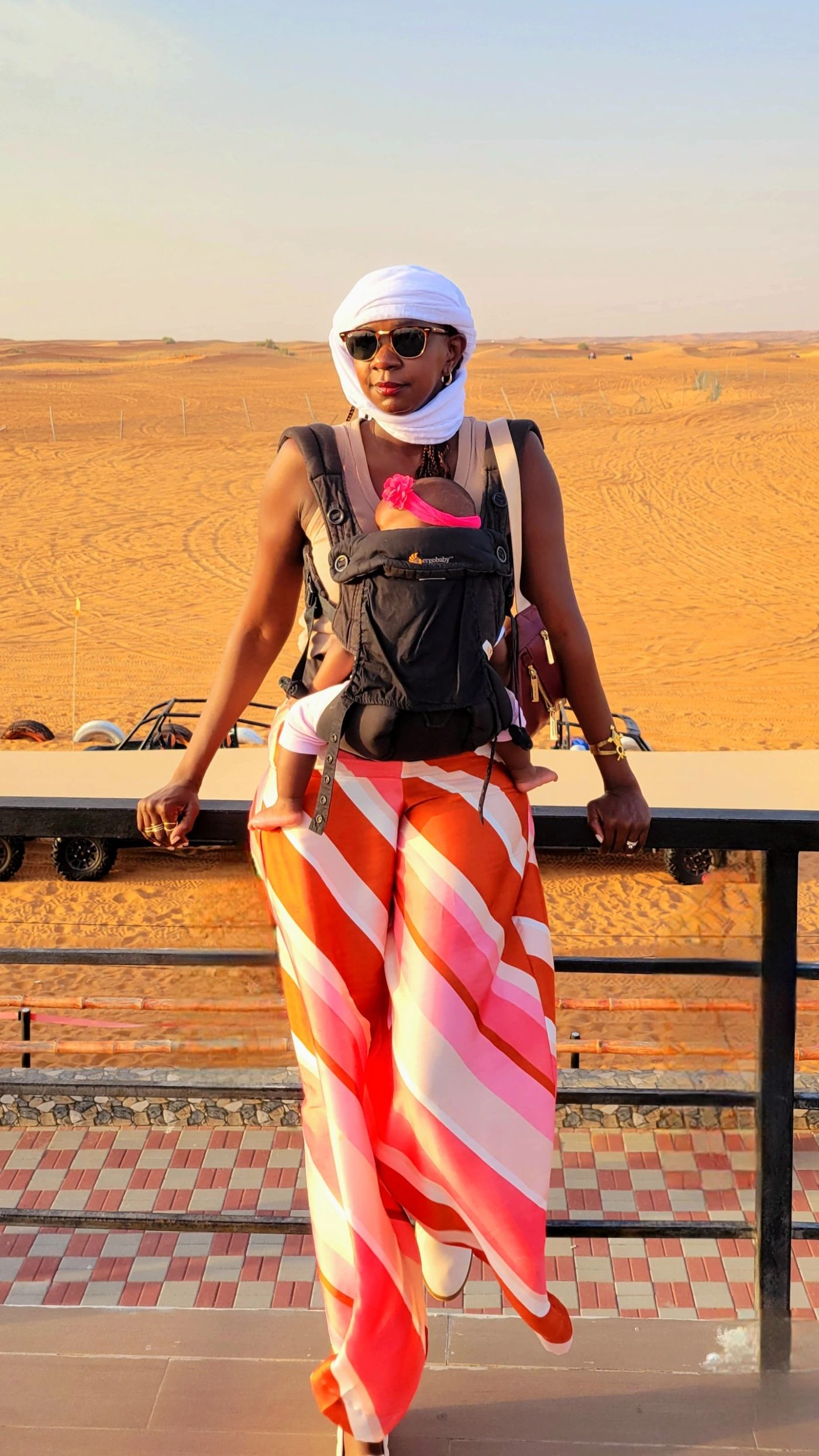 Samira with her baby in a baby carrier at a Dubai desert safari camp
